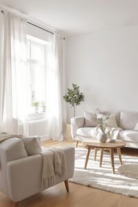 A bright and airy Scandinavian living room with soft natural daylight streaming through white sheer curtains, featuring light neutral furniture and a round wooden coffee table.